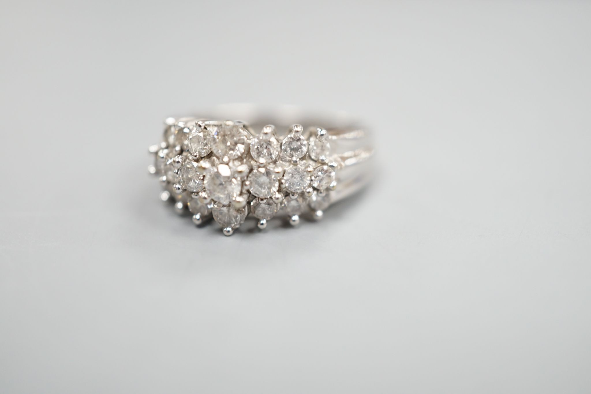 A modern 10k white metal and three row graduated diamond cluster set dress ring, size L, gross weight 4.3 grams.